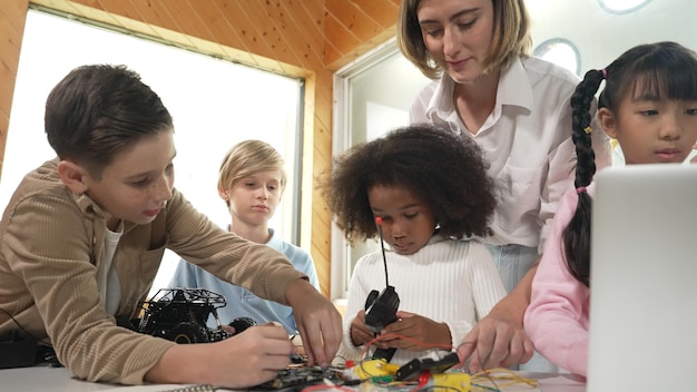 Photo smart teacher teaching students about car model or electrical tool erudition