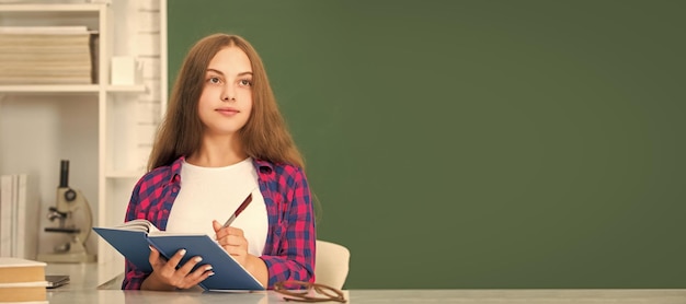 Фото Умная девочка-подросток готова учиться, ребенок делает домашнее задание с книгой