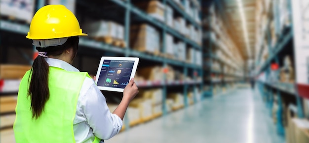 Smart warehouse management systemworker hands holding tablet on\
blurred warehouse as background