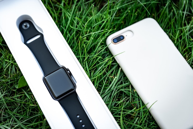 잔디 배경에 스마트 시계와 휴대 전화.