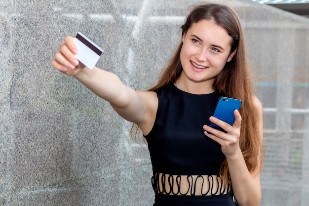 Photo smart woman buying online with a credit card and smart phone application.