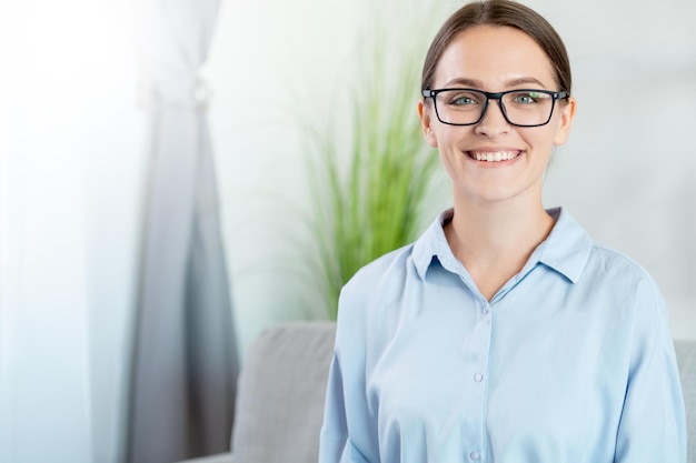 Photo smart woman portrait successful career positive lifestyle confident cheerful smiling female life coach in glasses at light home interior with free space