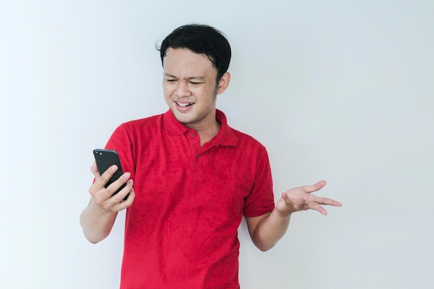 Smart Young Asian man is confused and stresses when look smartphone in studio background