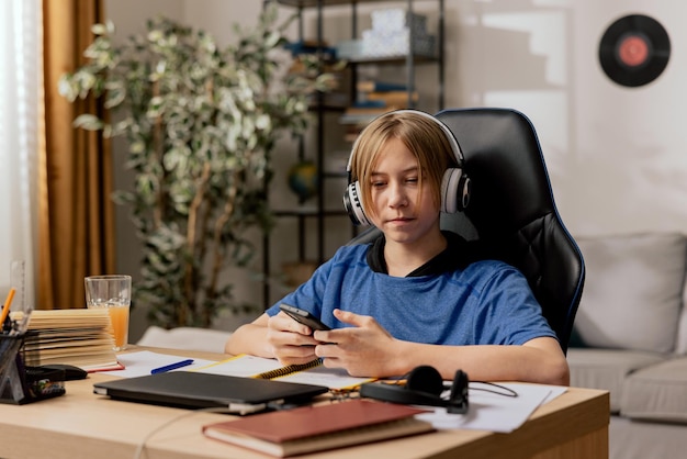 Smart young boy listens to podcasts on wireless headphones