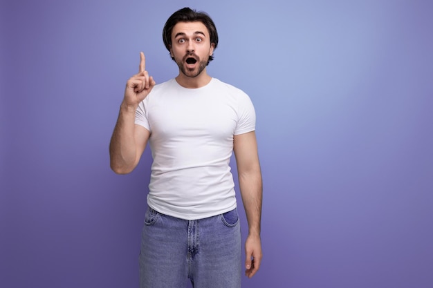 Smart young brutal brunette man in white tshirt and jeans with some idea