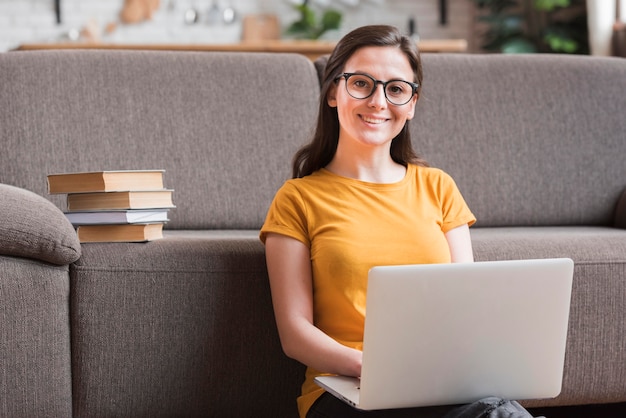 Foto intelligente giovane studente e pila di libri