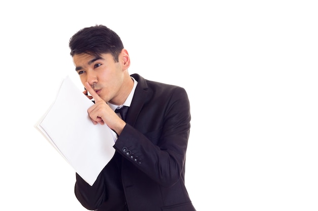 Smartlooking young man in white shirt and suit with tie holding papers and talking on the phone