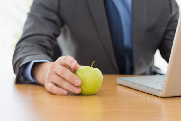 Photo smartly dressed businessman with laptop and apple at office