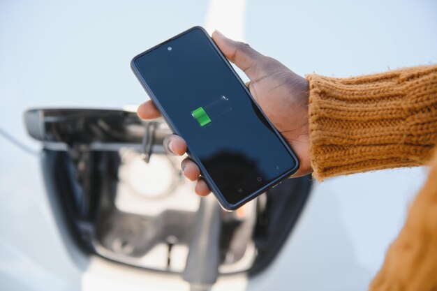 Smartphone-app toont laadstatus van de batterij van de elektrische auto. Elektro transportconcept