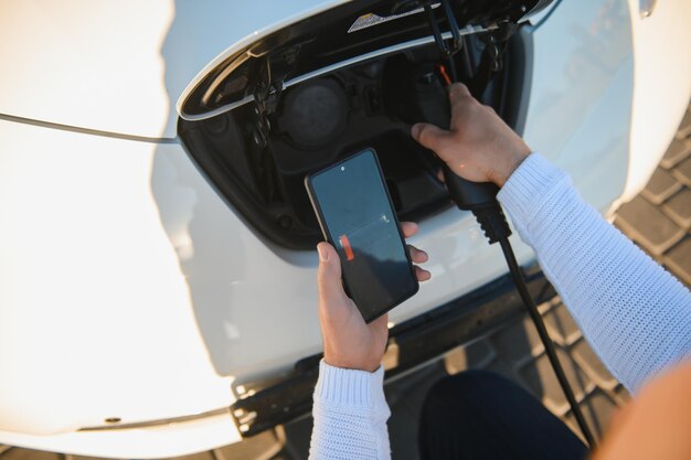 Smartphone-app toont laadstatus van de batterij van de elektrische auto. Elektro transportconcept