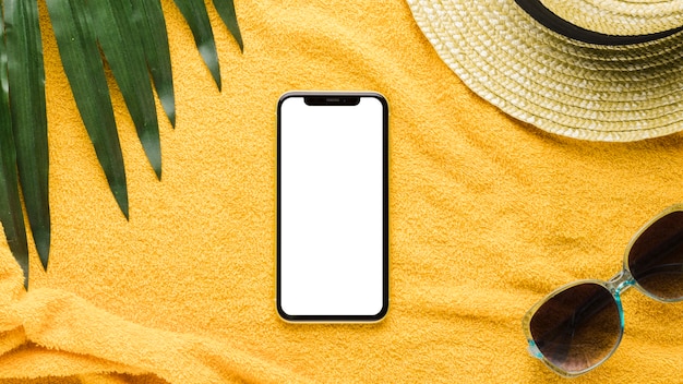 smartphone and beachfront accessories on light background