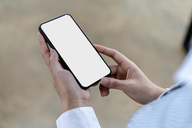 Smartphone blank screen, person holding smartphone and looking at blank screen, mockup screen for further editing can be used in a variety of tasks. copy space.