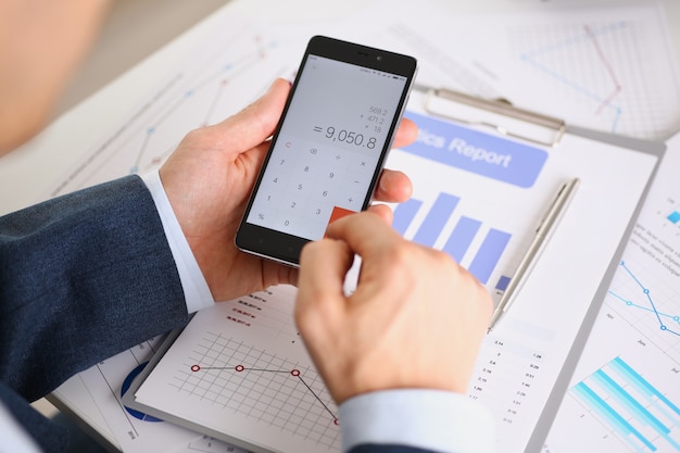 写真 スマートフォン電卓とインフォグラフィックの財務統計