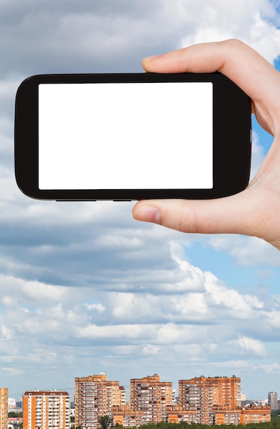 Smartphone and cloudy sky over city