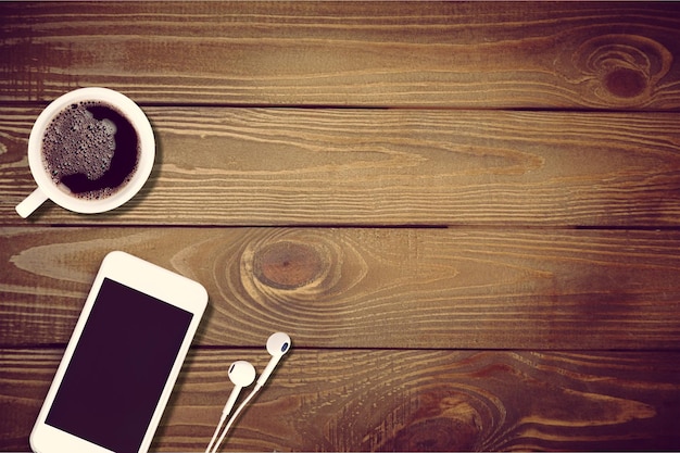 Smartphone cup of strong coffee on wooden background