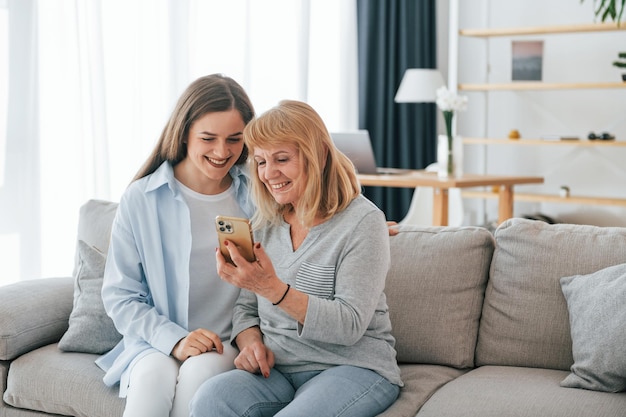 Smartphone gebruiken Moeder en dochter zijn samen thuis