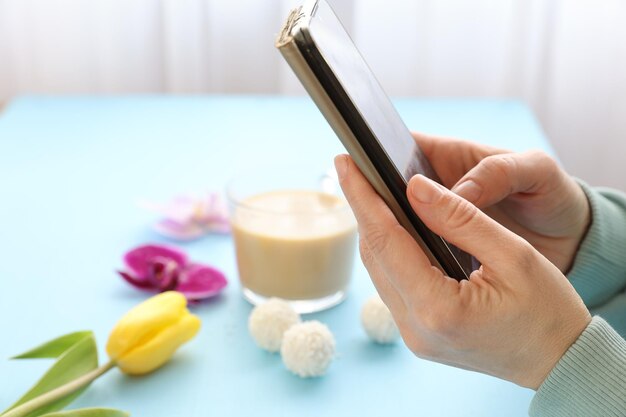 Smartphone in hand and breakfast on the table