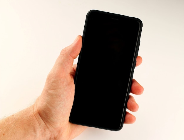 Smartphone in the hand on a white surface close up