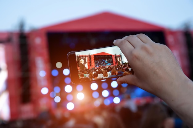 Smartphone in mano durante il concerto rock all'aperto