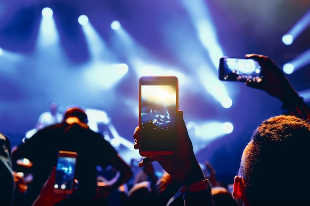 Smartphone in hands of fan during music show