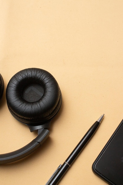 Smartphone and headset on beige background table office