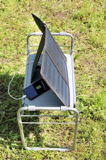 Photo smartphone hidden in the shadow is charged by solar energy