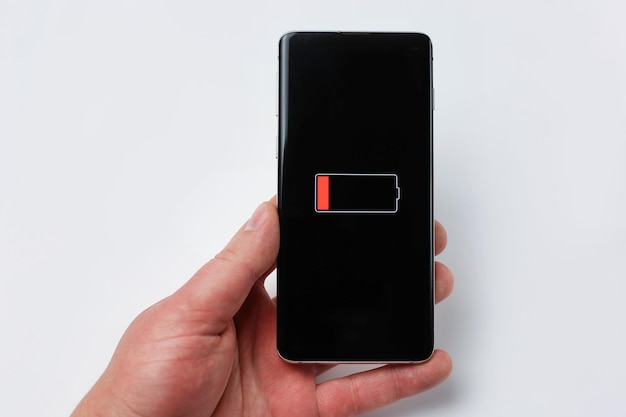 Foto smartphone in de hand met bijna lege batterij