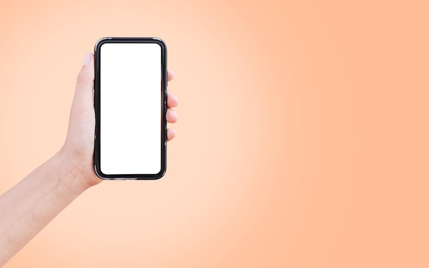 Smartphone in de hand met blanco op het scherm op de achtergrond van perzik fuzz kleur van het jaar