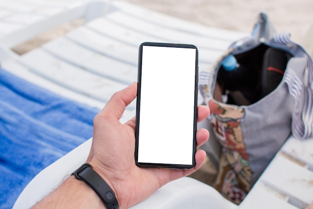 Smartphone in de hand op het strand