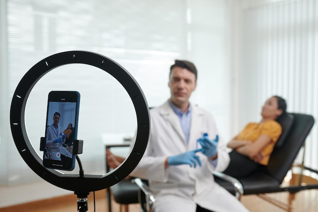 Foto smartphone ingesteld in ring licht streaming video over plastische chirurgie