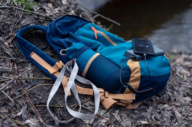 Smartphone is charged using a portable charger. Power Bank charges the phone outdoors with a backpack for tourism in nature.
