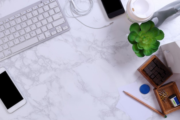 Smartphone, Kayboard and office supplies on marble background