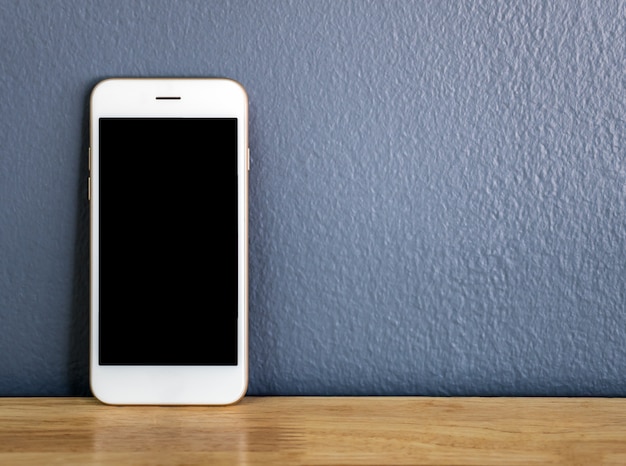 Smartphone leaning against the gray wall