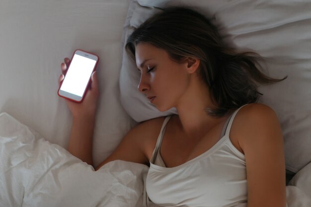 Smartphone che giace nella mano della donna mentre dorme.