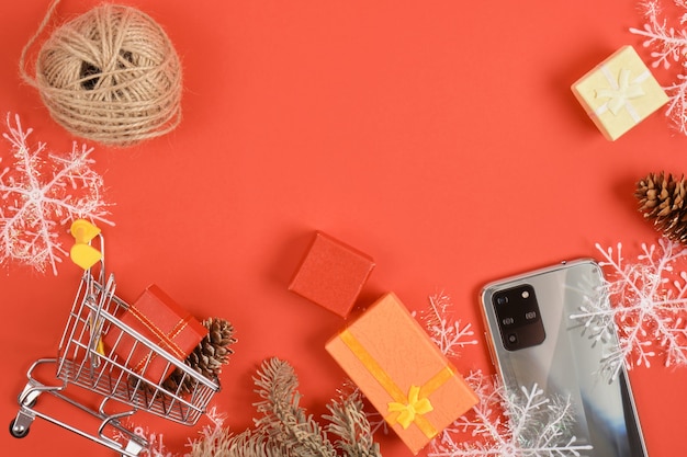 Foto smartphone met drie camera's en kerstdecor op een rode achtergrond