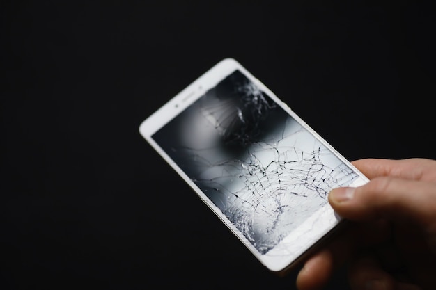 Smartphone met een gebroken touchscreen. Mobiele telefoon is kapot. De telefoon is gecrasht. Het vervangen van gebroken glas op een mobiele telefoon. Smartphone reparatie.