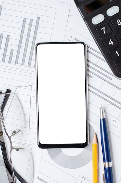 Smartphone met een leeg scherm op de achtergrond van grafieken en diagrammen. ruimte kopiëren. het concept van online beleggen of zakendoen of handelen in aandelen.