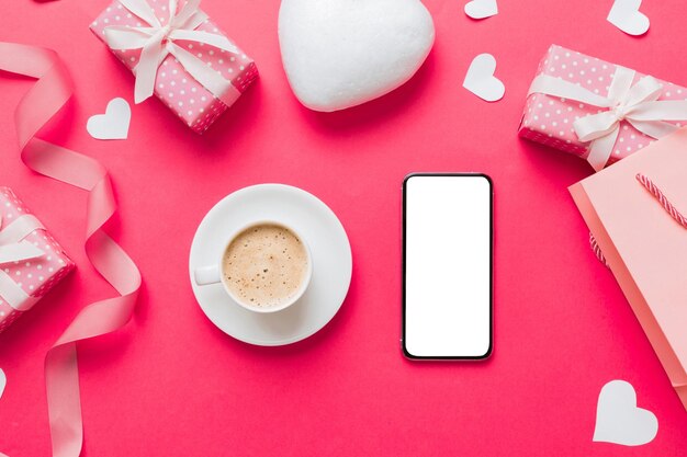 Smartphone met koffie voor Valentijnsdag geschenkdoos en enveloppe harten