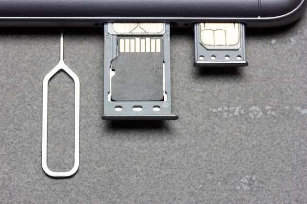 Smartphone met open SIM-slots en micro SD-geheugen op een grijze achtergrond