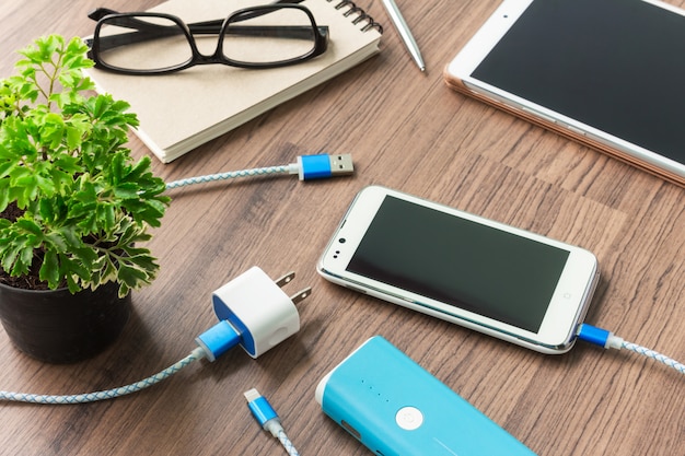 Smartphone met USB-kabel en adapter op het bureau