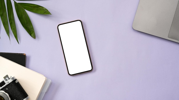 Smartphone mockup laptop camera and notebook on purple workspace background top view