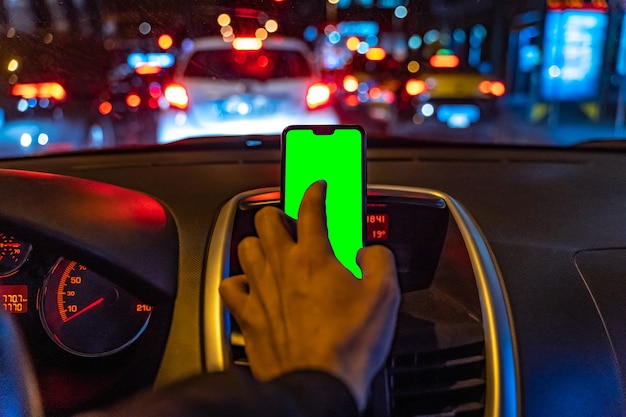 Smartphone mockup with green screen in the car while driving to add GPS or App