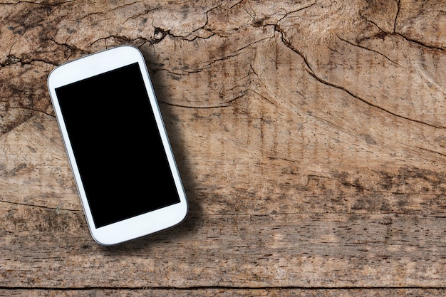 Smartphone on old wooden table background