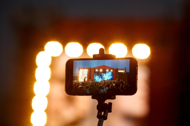 Smartphone op selfie monopod stick. Achtergrond van concertshow