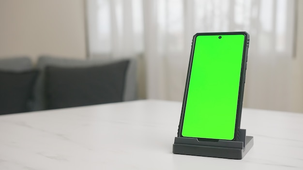 Foto smartphone op tafel met groen scherm