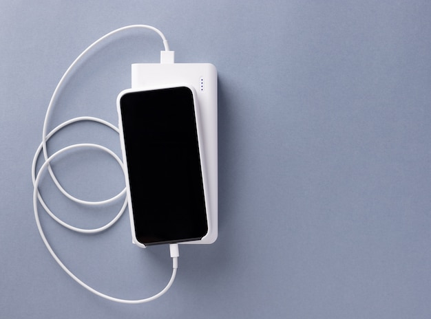 Foto smartphone opgeladen via een usb-kabel van de powerbank-oplader