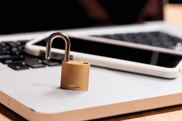 Smartphone and padlock is lying on a laptop keyboard