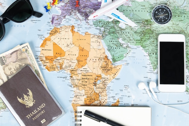 Smartphone passport and money with compass on map for travel plan