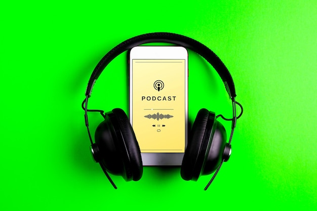 Foto smartphone che riproduce un podcast telefono cellulare e cuffie su sfondo verde concetto di ascolto di podcast