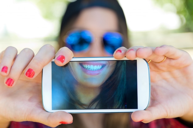 スマートフォンの画面中の女性を作る自分撮り